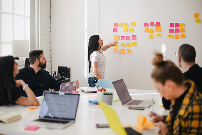 Un gruppo di lavoro davanti a una parete di post-it